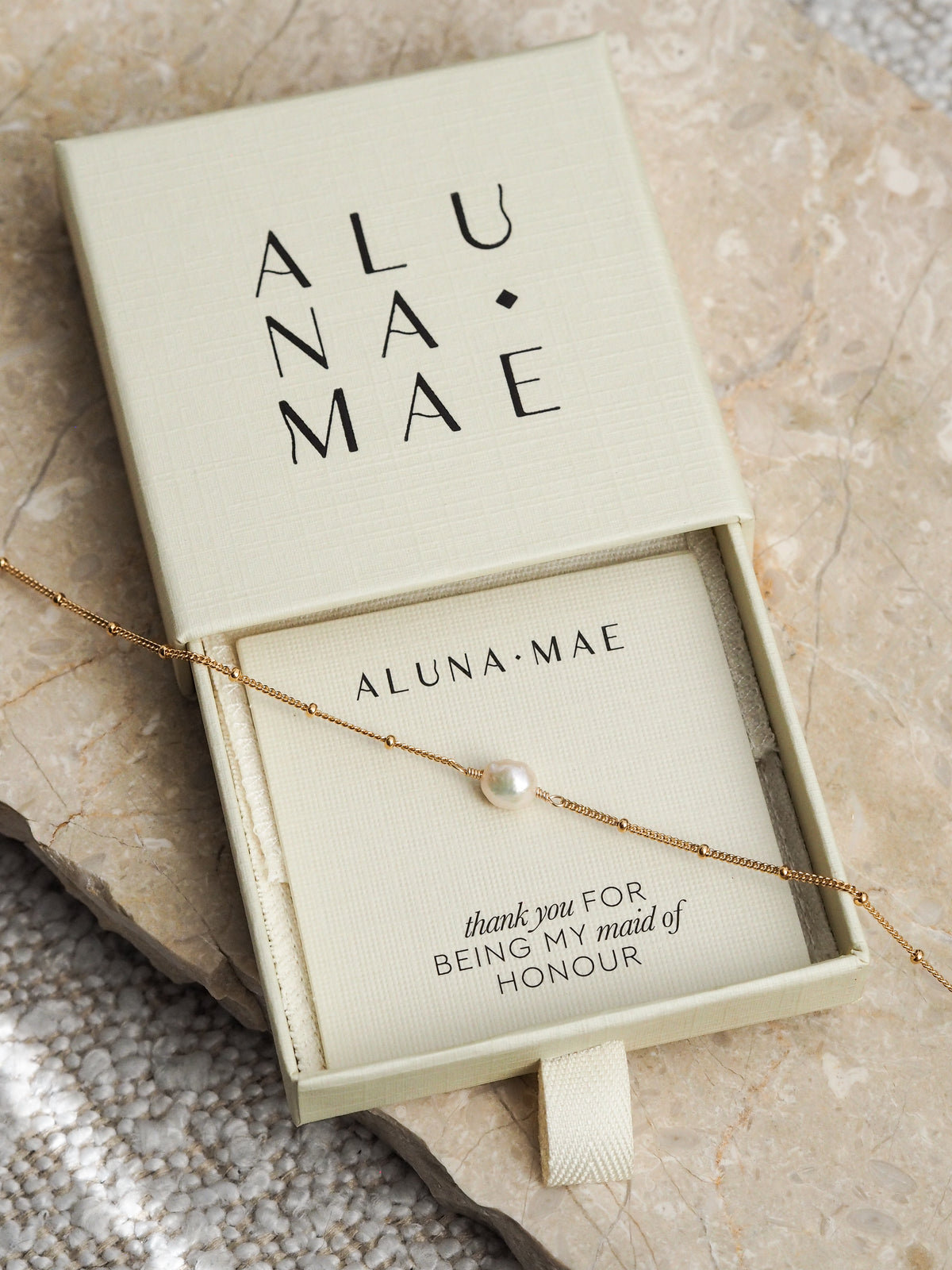 Gold chain bracelet with a single freshwater pearl displayed in an Aluna Mae gift box with a "thank you for being my maid of honour" card.