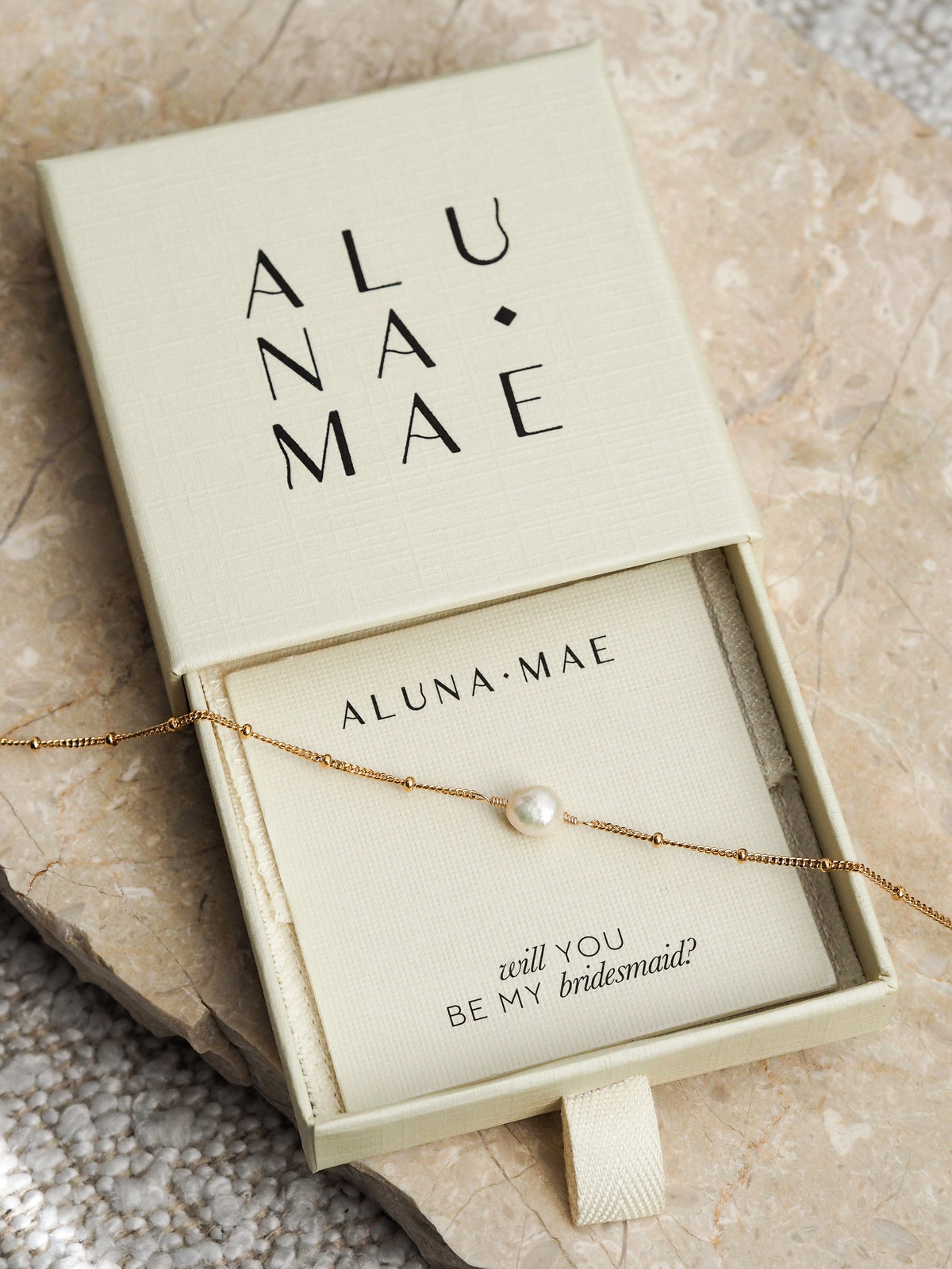 Gold chain bracelet with a single freshwater pearl in an Aluna Mae gift box featuring a "will you be my bridesmaid?" message card.