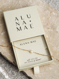 Gold chain bracelet with a single freshwater pearl in an Aluna Mae gift box featuring a "will you be my maid of honour?" message card.