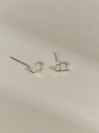 Pair of rectangular silver stud earrings with mother of pearl inlays, displayed on a neutral background.