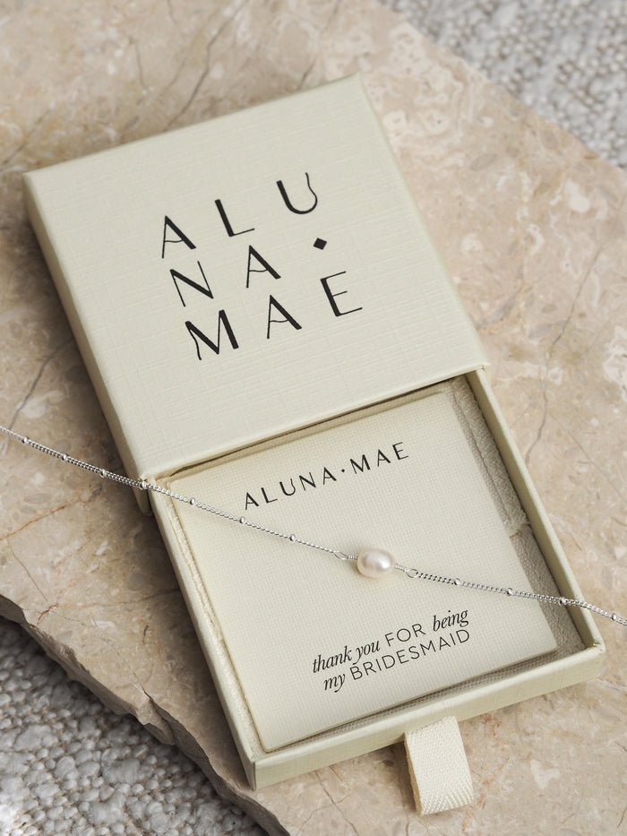 Silver chain bracelet with a single freshwater pearl, displayed in an Aluna Mae gift box with a “thank you for being my bridesmaid” card.