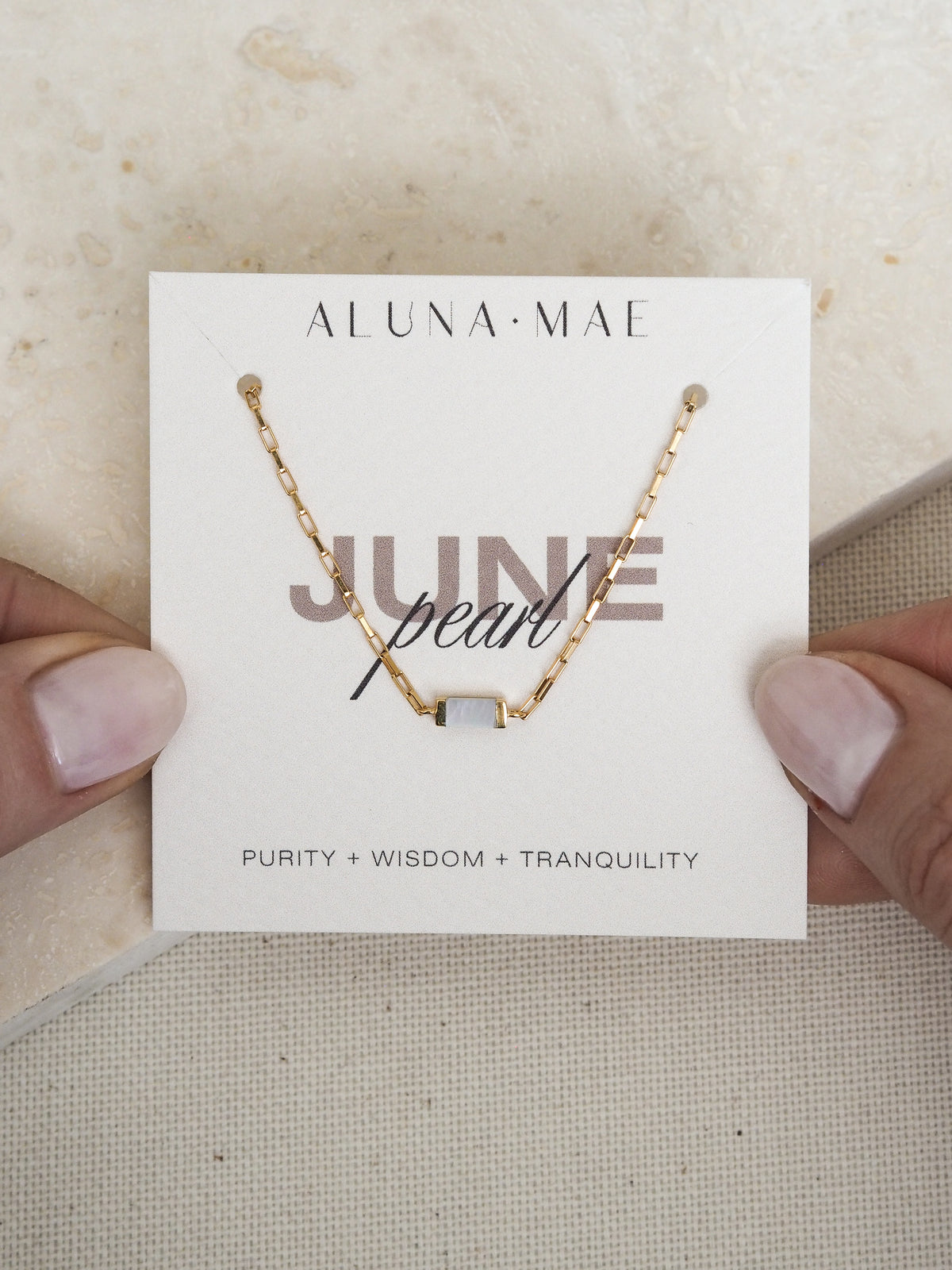 June birthstone bracelet featuring a rectangular mother of pearl stone on a radiant 18ct gold plated box chain, displayed on an Aluna Mae birthstone card.
