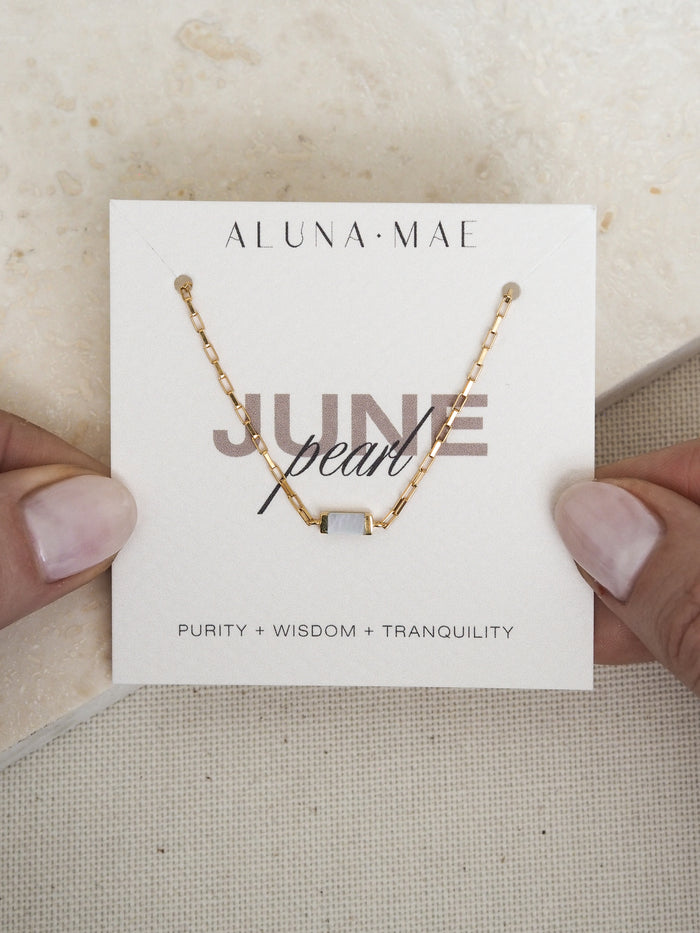 June birthstone bracelet featuring a rectangular mother of pearl stone on a radiant 18ct gold plated box chain, displayed on an Aluna Mae birthstone card.