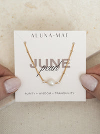 June birthstone necklace featuring a single freshwater pearl on a delicate 18ct gold plated sterling silver satellite chain, displayed on an Aluna Mae birthstone card with the words “Purity + Wisdom + Tranquility.