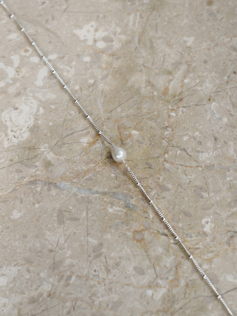 Close-up of a sterling silver freshwater pearl satellite chain necklace.