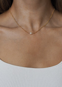 Close-up of a model wearing a freshwater pearl gold satellite chain necklace.