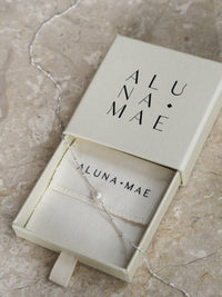 Freshwater pearl necklace with a sterling silver satellite chain, displayed in an Aluna Mae gift box on a neutral marble surface.