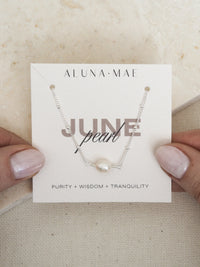 June birthstone necklace featuring a freshwater pearl on a sterling silver satellite chain, presented on an Aluna Mae card with birthstone meanings.