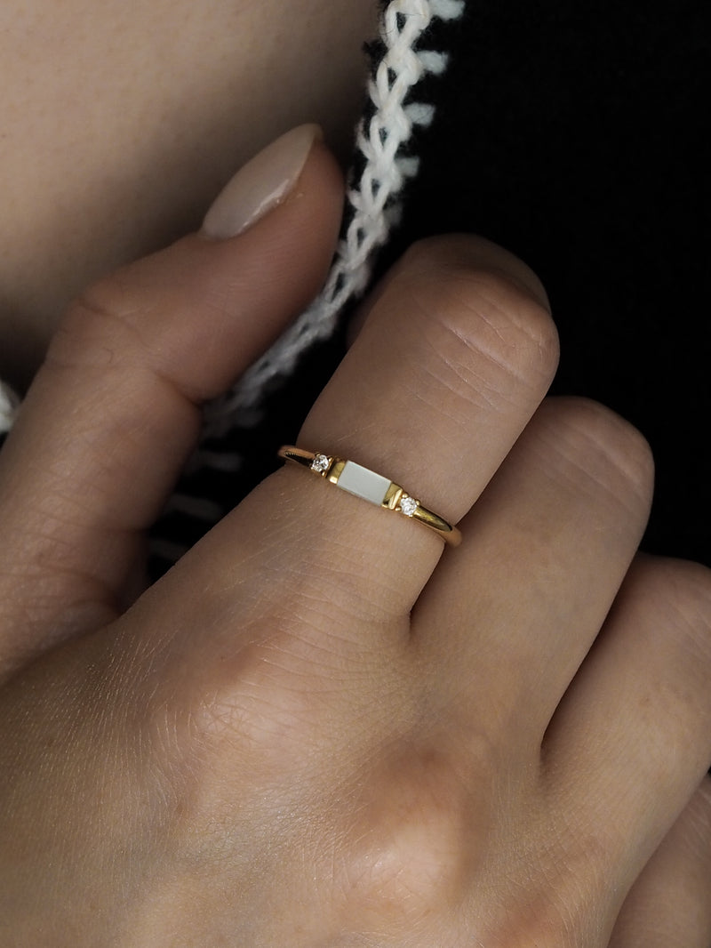 Gold vermeil ring with a rectangular mother of pearl stone and two cubic zirconia accents, shown worn on a hand.