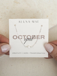 October opal birthstone necklace with sterling silver satellite chain on Aluna Mae card featuring birthstone meaning